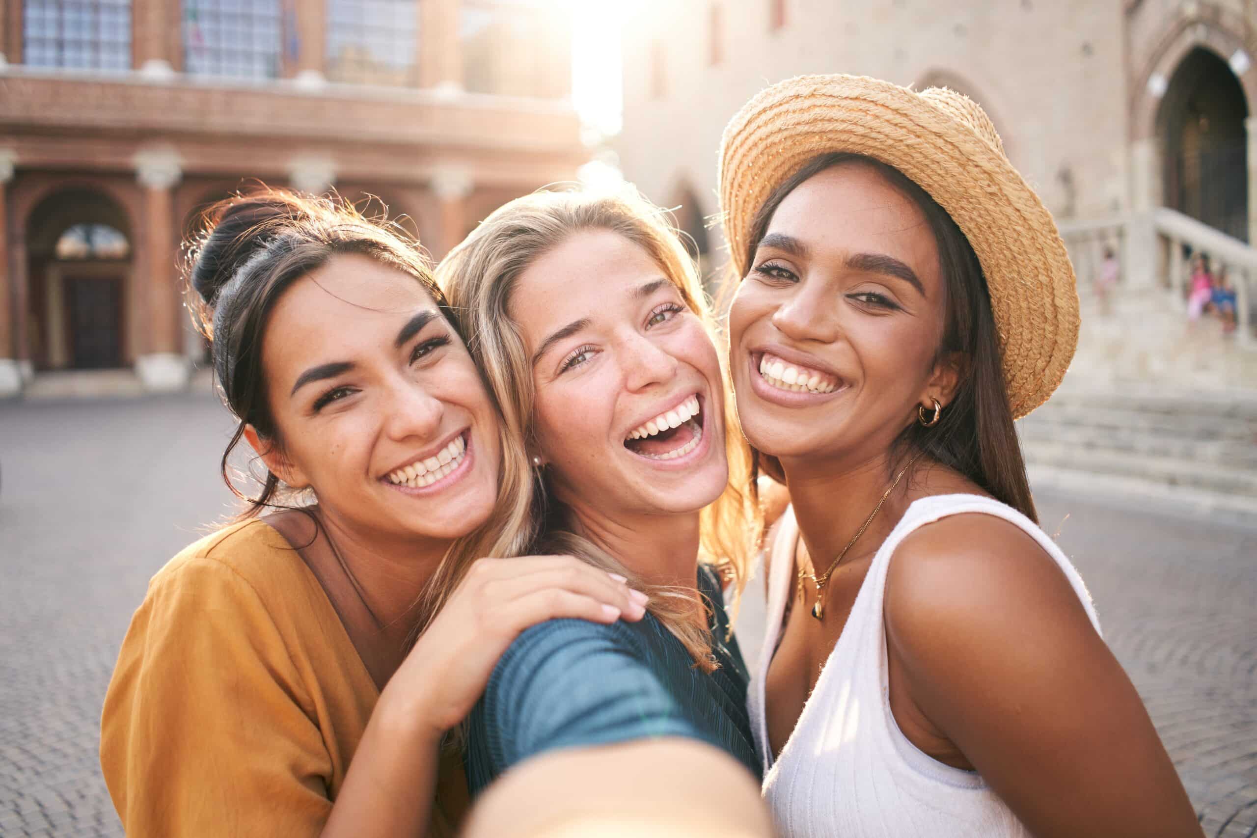Three women smiling outside